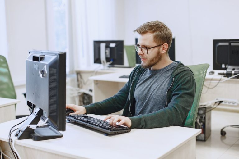 a man wearing eyeglasses while looking at the computer